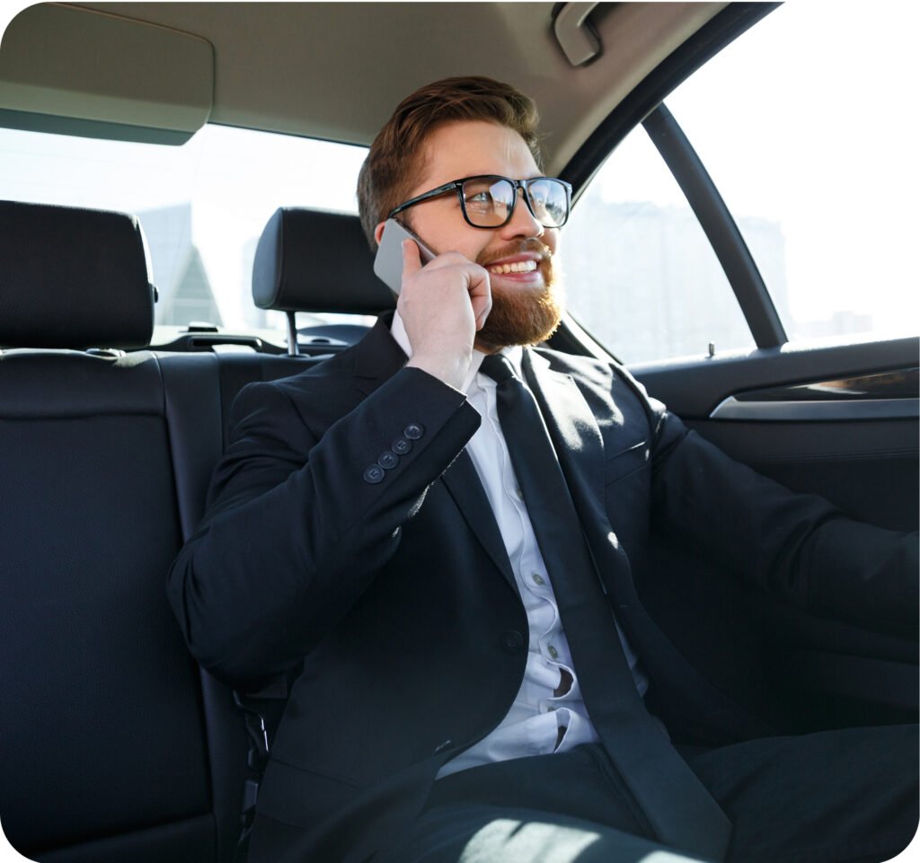 Homme d’affaires souriant parlant au téléphone dans la voiture