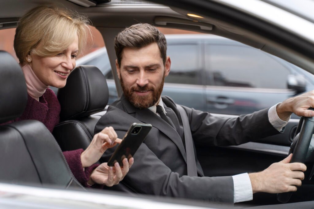 Homme et femme utilisant leur téléphone dans la voiture